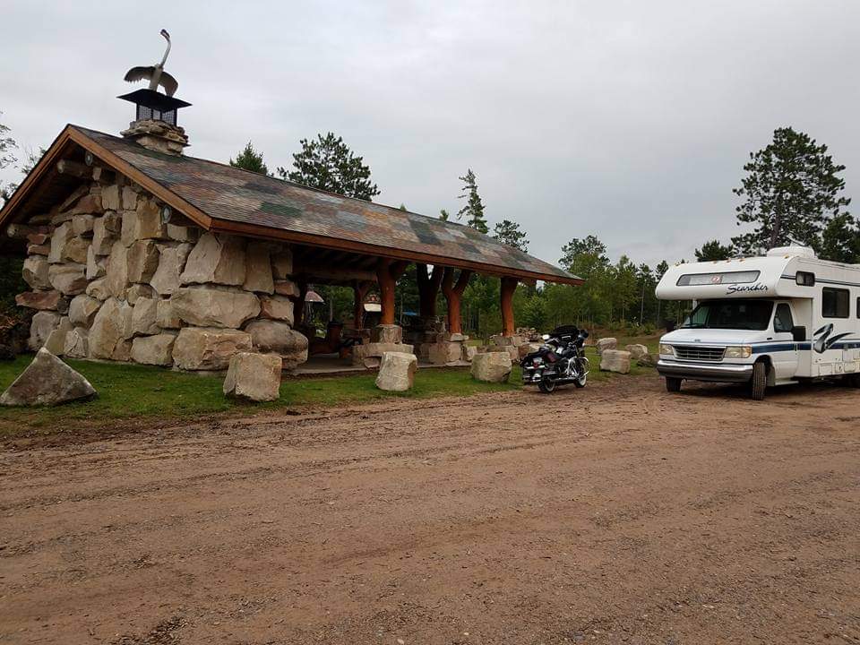 Picture one of the pavilions in Lakenenland Sculpture park, made from stone, wood, and metal. This pavilion also features a fireplace to warm up.